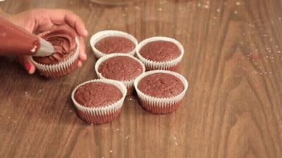 Person Frosting Cupcakes With Chocolate GIF