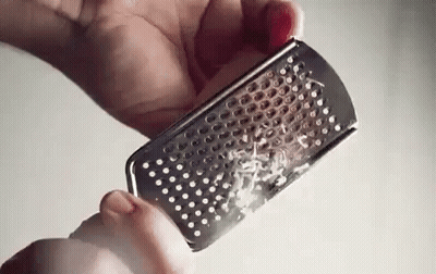 Person Grating Cheese On Grater GIF