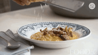 Person Grating Cheese On Plate With Number 52 GIF