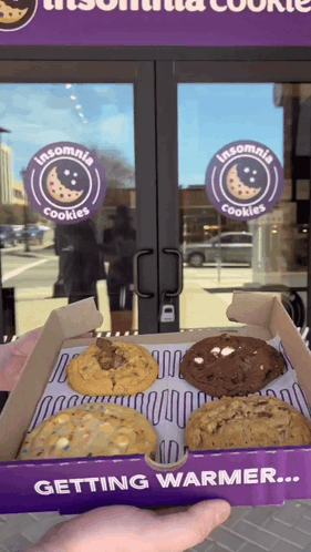 Person Holding A Box Of Insomnia Cookies In Front Of A Store GIF