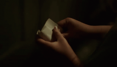 person holding a piece of paper that says in here