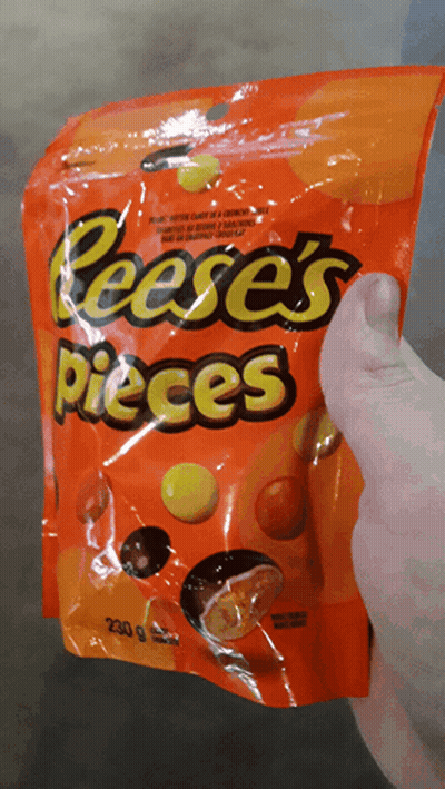 Person Holding Bag Of Reese's Pieces GIF