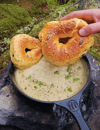 Person Holding Bagel Over Soup GIF