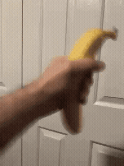 Person Holding Banana In Front Of Door GIF