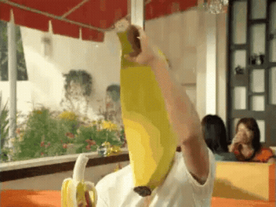 Person Holding Banana Over Head In Restaurant GIF
