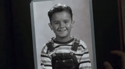 Person Holding Black And White Photo Of Boy In Overalls GIF