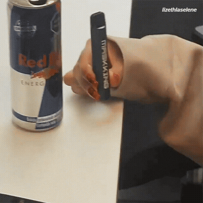 Person Holding Black King Device Next To Red Bull Can GIF