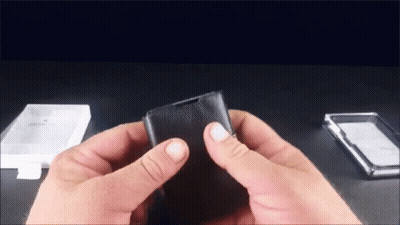 Person Holding Black Leather Wallet Next To Clear Plastic Case GIF