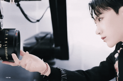 Person Holding Camera With Number 2 On Lens GIF