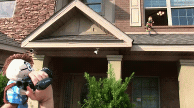 Person Holding Canon Camera In Front Of Brick House GIF