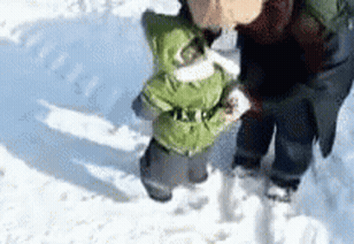 Person Holding Child Walking in Snow
