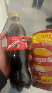 Person Holding Coca Cola Bottle Next To Bag Of Margaritas GIF