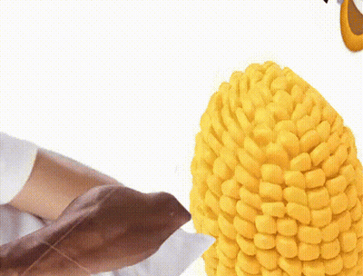 Person Holding Corn On The Cob With Knife GIF