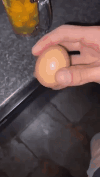Person Holding Egg In Front Of Orange Juice GIF