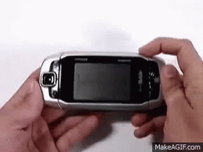Person Holding Flip Phone Looking At It GIF