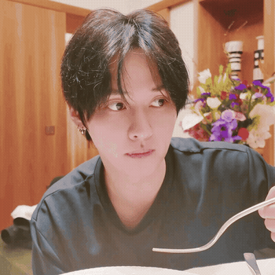 Person Holding Fork In Front Of Flower Arrangement GIF