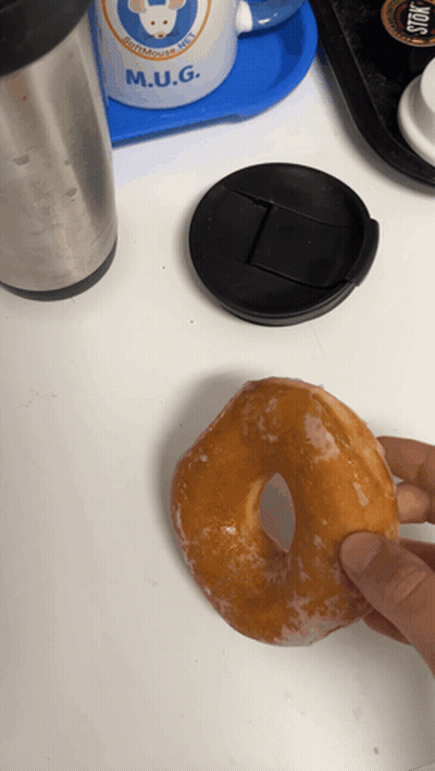 Person Holding Glazed Donut And M.U.G. Mug GIF