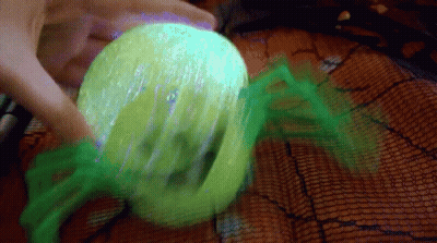 Person Holding Green Ball With Spider Web GIF
