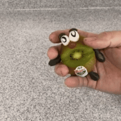 Person Holding Kiwi With Googly Eyes And Legs GIF