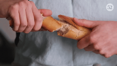 Person Holding Loaf Of Bread With Number 52 GIF