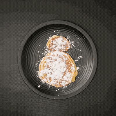 Person Holding Orange Slice Over Pancake GIF