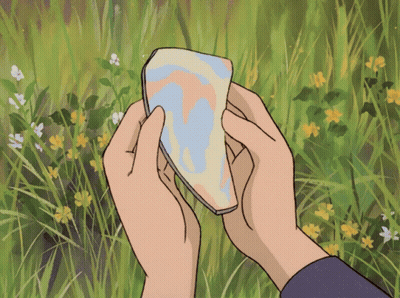 Person Holding Paper In Flower Field GIF