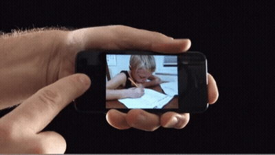 Person Holding Phone With Child Writing GIF