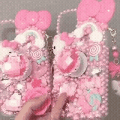Person Holding Pink Hello Kitty Phone Case And Purse GIF