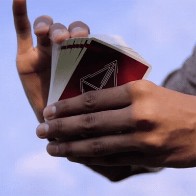 Person Holding Playing Cards With Triangle Back