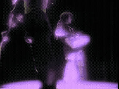 Person Holding Purple Object In Dark Room GIF