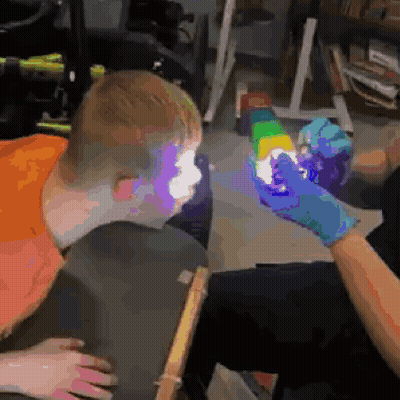 Person Holding Rainbow Cube In Front Of Boy's Face GIF