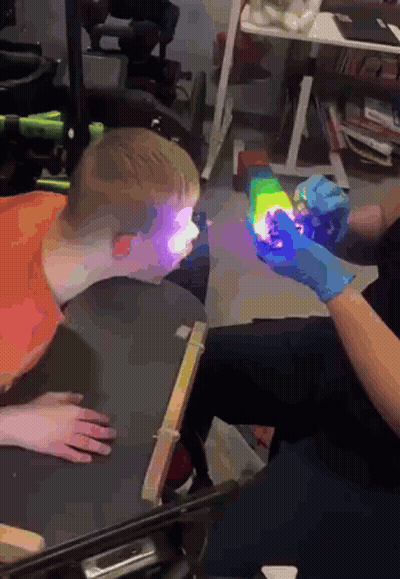 Person Holding Rainbow Object In Front Of Child GIF