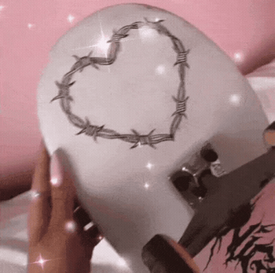 Person Holding Skateboard With Heart of Barbed Wire