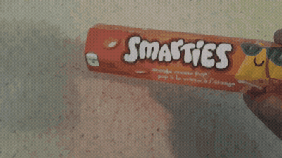 Person Holding Smarties Orange Cream Pop Bar GIF
