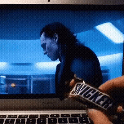 Person Holding Snickers Bar In Front Of Computer GIF