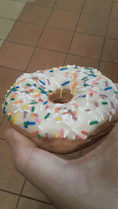 Person Holding Sprinkled Donut GIF