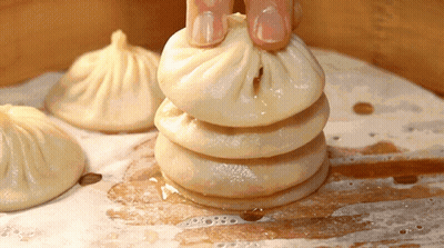 Person Holding Stack Of Dumplings GIF