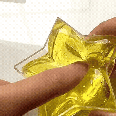 Person Holding Star-Shaped Object With Yellow Liquid GIF