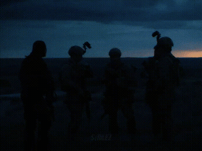 Person Holding Suited Cartoon With Two Guns GIF