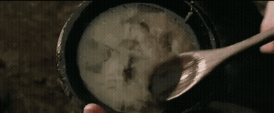 Person Holding Wooden Spoon Over Bowl Of Soup GIF