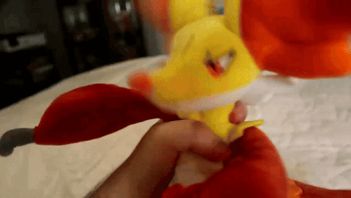 Person Holding Yellow and Orange Stuffed Animal