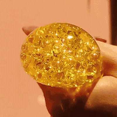 Person Holding Yellow Ball With Sparkles GIF