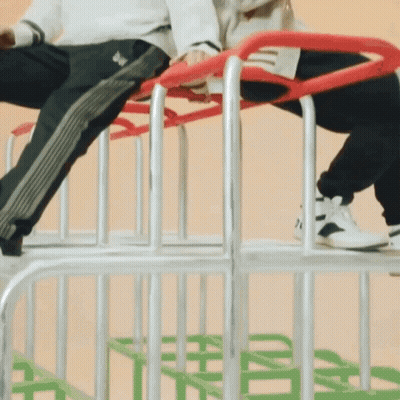 Person In Adidas Pants Sitting On Metal Fence GIF