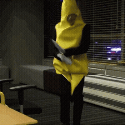 Person In Banana Costume Standing At Window GIF