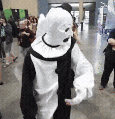 Person In Black And White Clown Costume In Crowd GIF