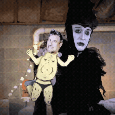 Person In Black And White Costume Holding Puppet GIF