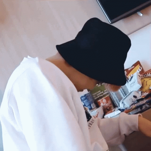 Person In Black Bucket Hat Sitting At Table Eating Chips GIF