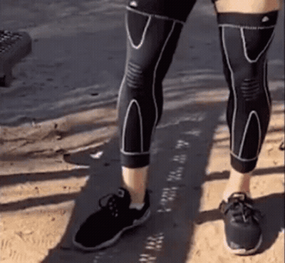 Person In Black Knee Braces And Shoes On Sandy Beach GIF