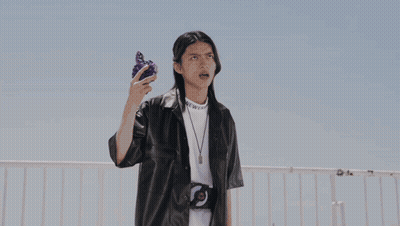 Person In Black Leather Jacket Holding Purple Object GIF