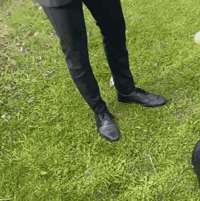 Person In Black Pants And Shoes Standing In Grass GIF